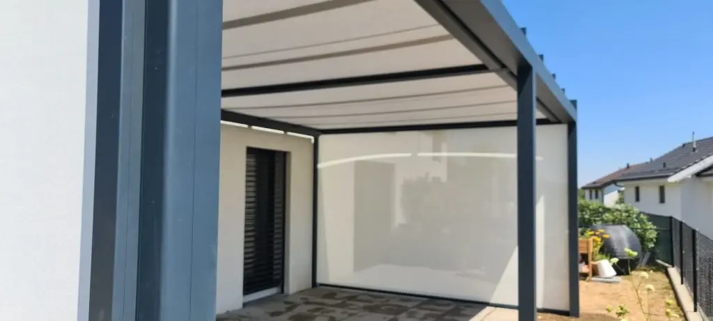 Écran vertical clair intégré à une terrasse couverte pour réduire l'ensoleillement direct et préserver l'intimité.